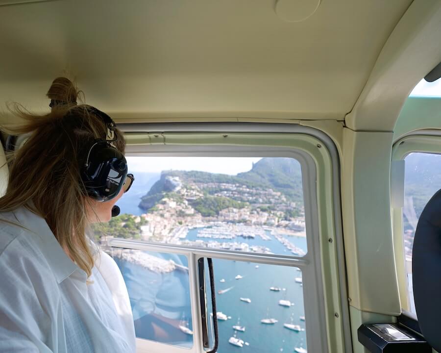 Helicopter Passenger looking out of the window with Port de Soller Mallorca view
